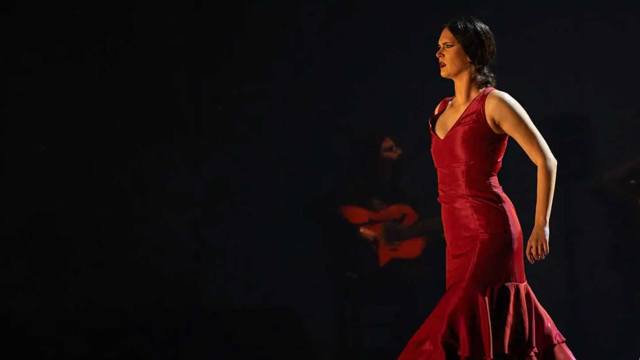 Bailaora de flamenco con vestido rojo de volantes avanzando por el escenario